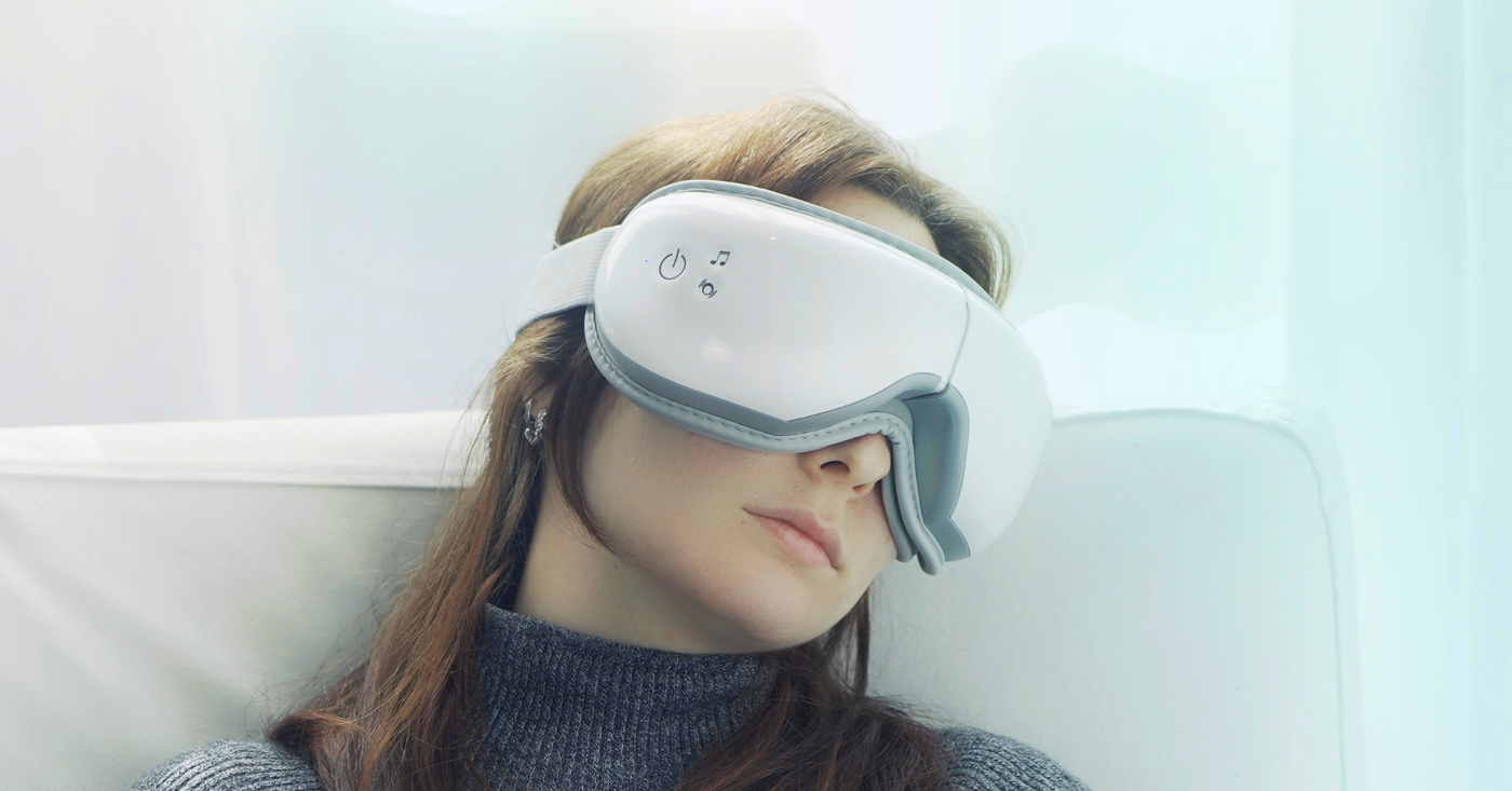 A woman using a Renpho eye massager to relax.