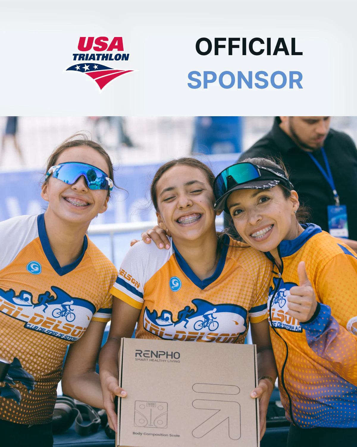 Three female cyclists in USA triathlon jerseys, smiling and posing together at an event focused on health, with one holding the Elis Aspire Smart Body Scale.