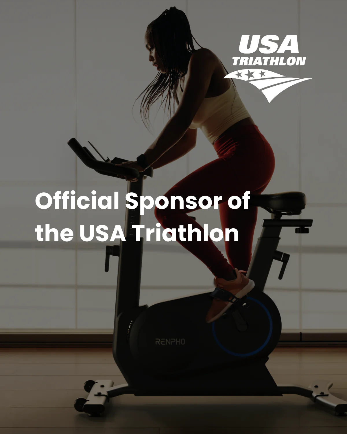 A person is riding the AI Smart Bike S by Renpho AU indoors, engaging in an immersive fitness experience. The image features the text "Official Sponsor of USA Triathlon" and has a USA Triathlon logo in the top right corner. The athlete appears focused and dressed in athletic wear, with a large window in the background.